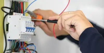 Electrician installing and adjusting circuit breakers in an electrical panel in Birmingham, AL