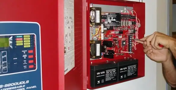 fire alarm installation service showing technician configuring fire alarm control panel in Birmingham, AL
