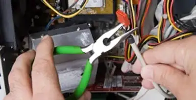 Licensed electrical contractor performing electrical repair with tools in Fairfield, AL