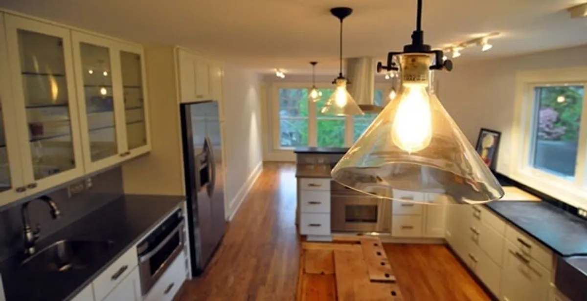 Residential electrician installing modern indoor light fixture in a home in Birmingham, AL