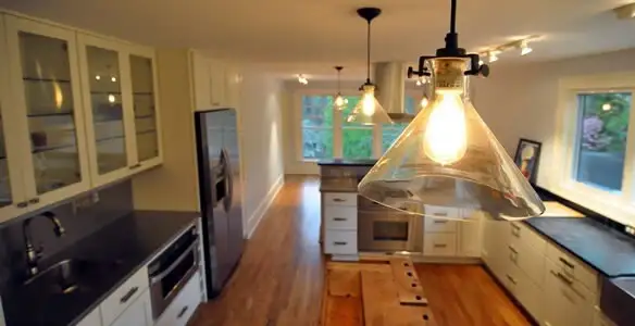 Residential electrician installing modern indoor light fixture in a home in Birmingham, AL